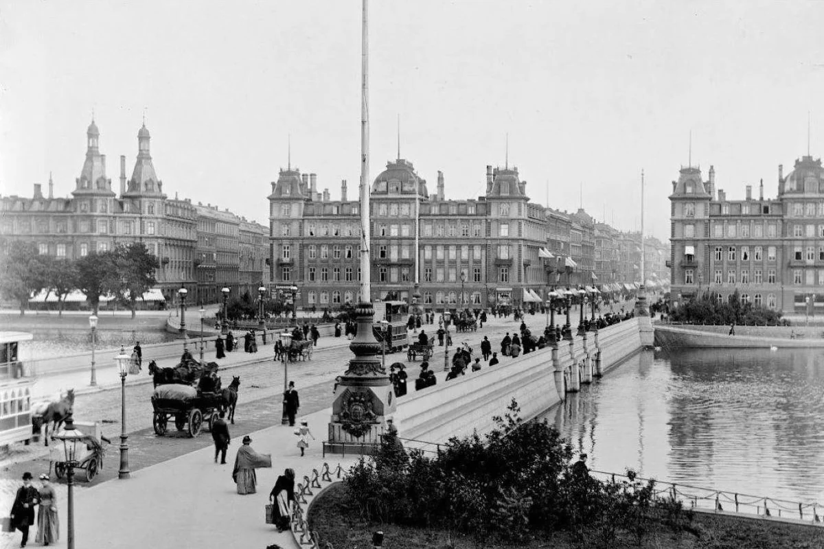 Nørrebro 1928: Københavnerliv - søpromenade. Byens hjerte mellem Nørrebro og Indre By bindes sammen af Dronning Louises Bro. Her en smuk dag, hvor byens borgere promenerer - det ser ud til at have holdt tørt. Billedet er taget fra Nørrebrosiden. (Foto: Københavns Museum)